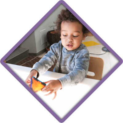 Child playing with toys at a light table